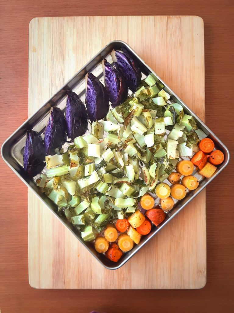 Top view of roasted cauliflower greens with carrots and purple cabbage