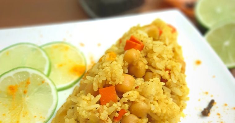 Yello Rice on a plate with pepper, lime and spices
