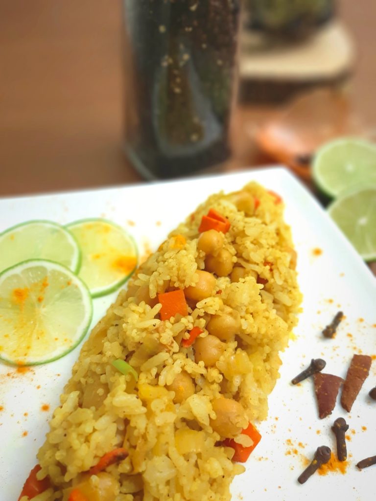 Yello Rice on a plate with pepper, lime and spices