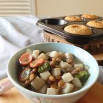 Potato and Leek stew with hot dog slices on top and lentils. Corn dog muffins in the background