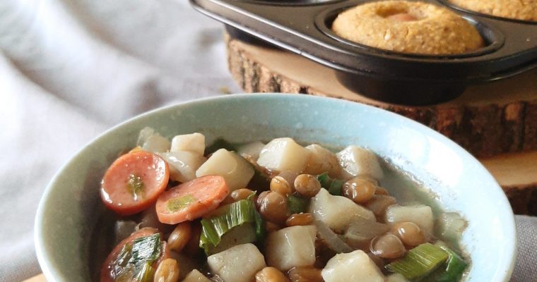 Potato and Leek stew with hot dog slices on top and lentils. Corn dog muffins in the background