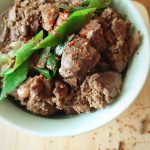five-spice chicken liver with leeks in a bowl with spices in the background