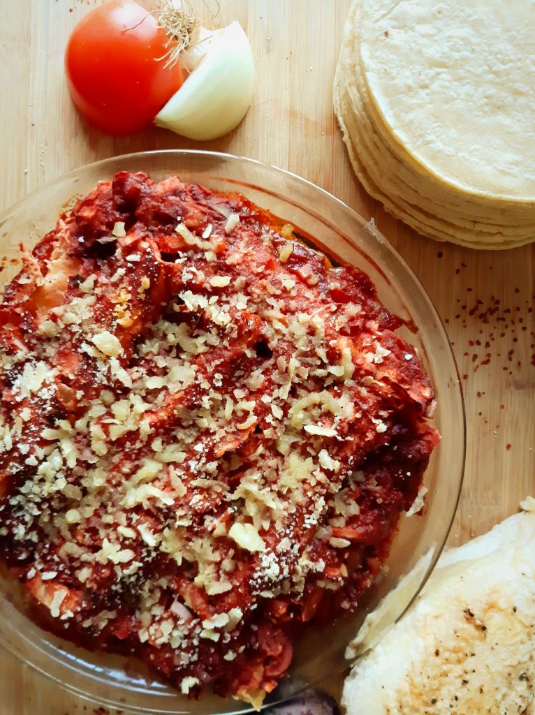 Chicken enchilada with beets and tomato sauce top view