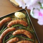 Sausage Sheet-pan Dinner top view with blurred flowers