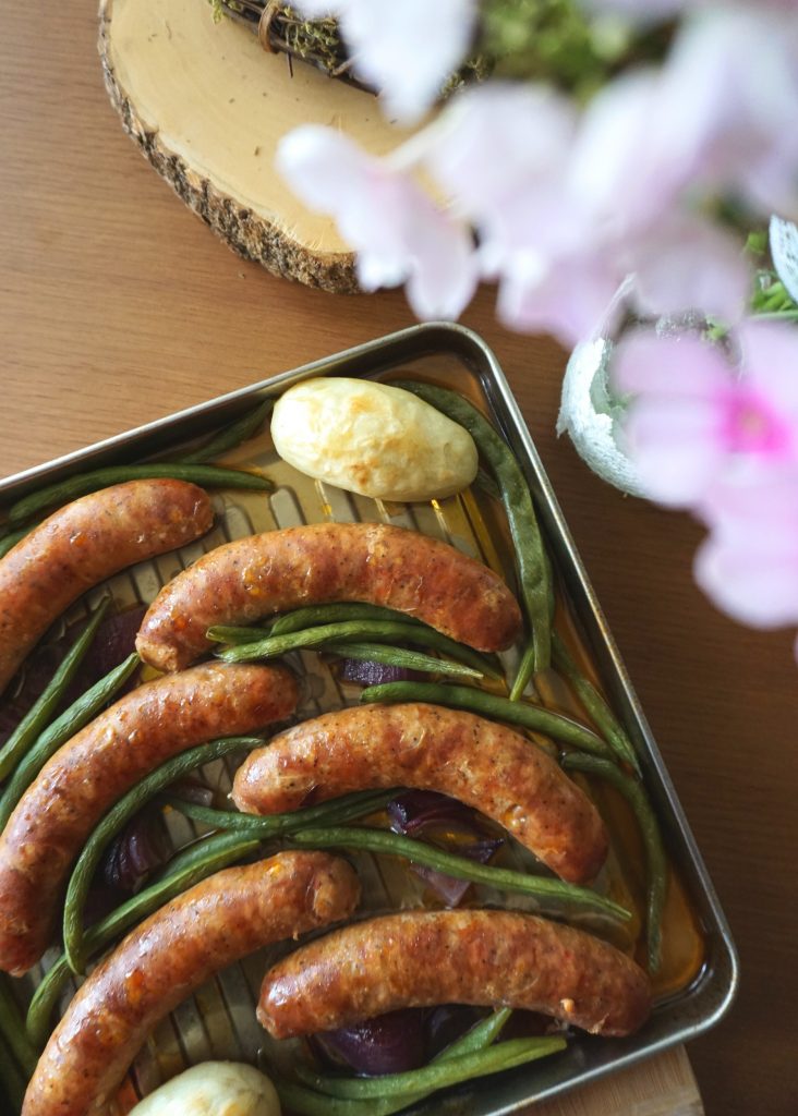 Sausage Sheet-pan Dinner top view with blurred flowers