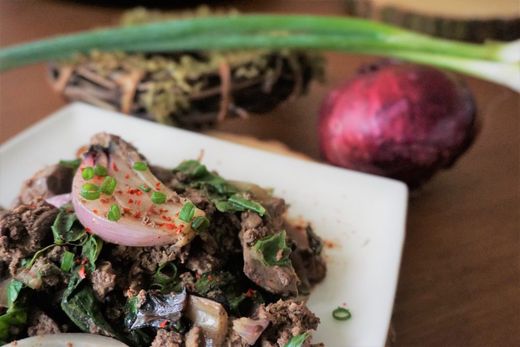 Chicken liver and onions with red onion and green onion in the background