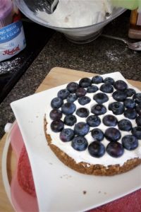 Base layer cake with icing and blueberries on top