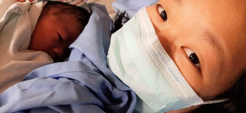 Brenda holding Giddy in hospital bed after birth