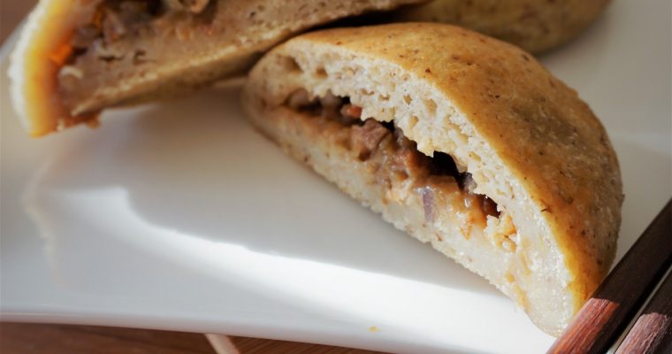 Cross section of gluten free baked bbq pork buns on a plate with chopsticks